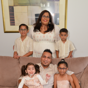 photo of Zita, her husband and 4 children sitting on a couch